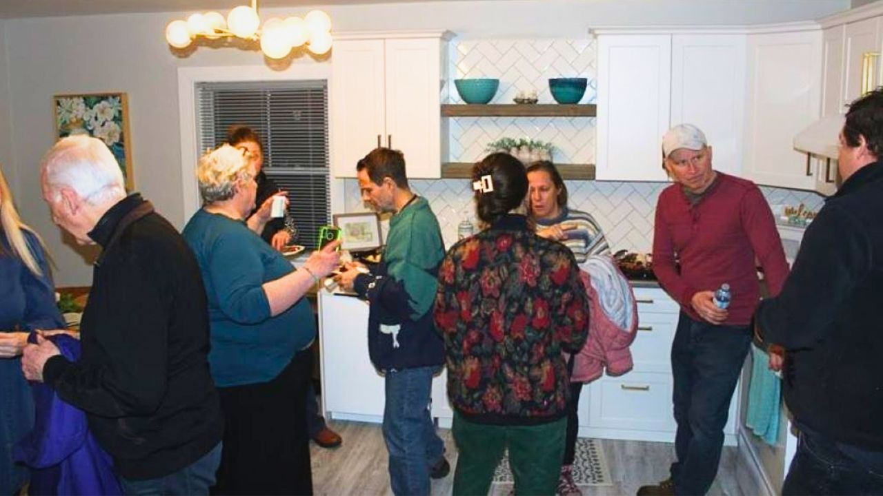 group of people talking in a kitchen