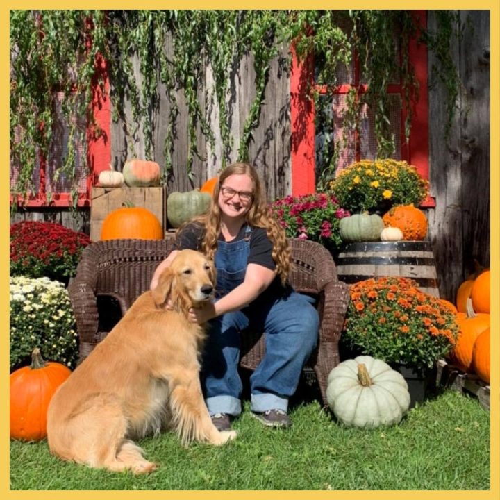 Photo of a producer with a dog and pumpkins