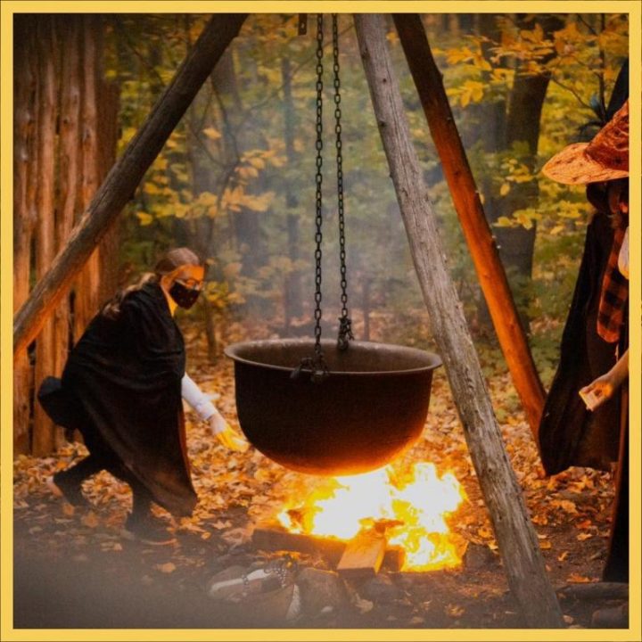 Halloween witch brewing a pot on an open fire