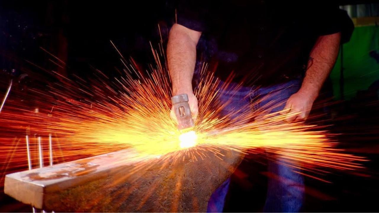 man blacksmithing and sparks flying