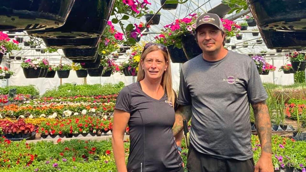 owners in greenhouse smiling