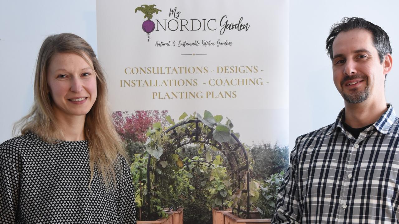 owners smiling and standing in front of my nordic garden banner